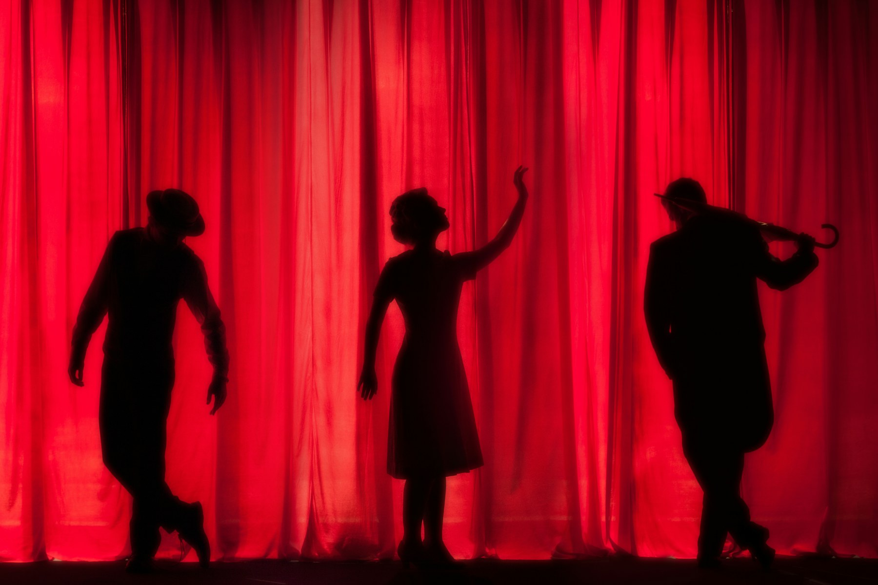 Silhouettes devant un rideau de velours rouge